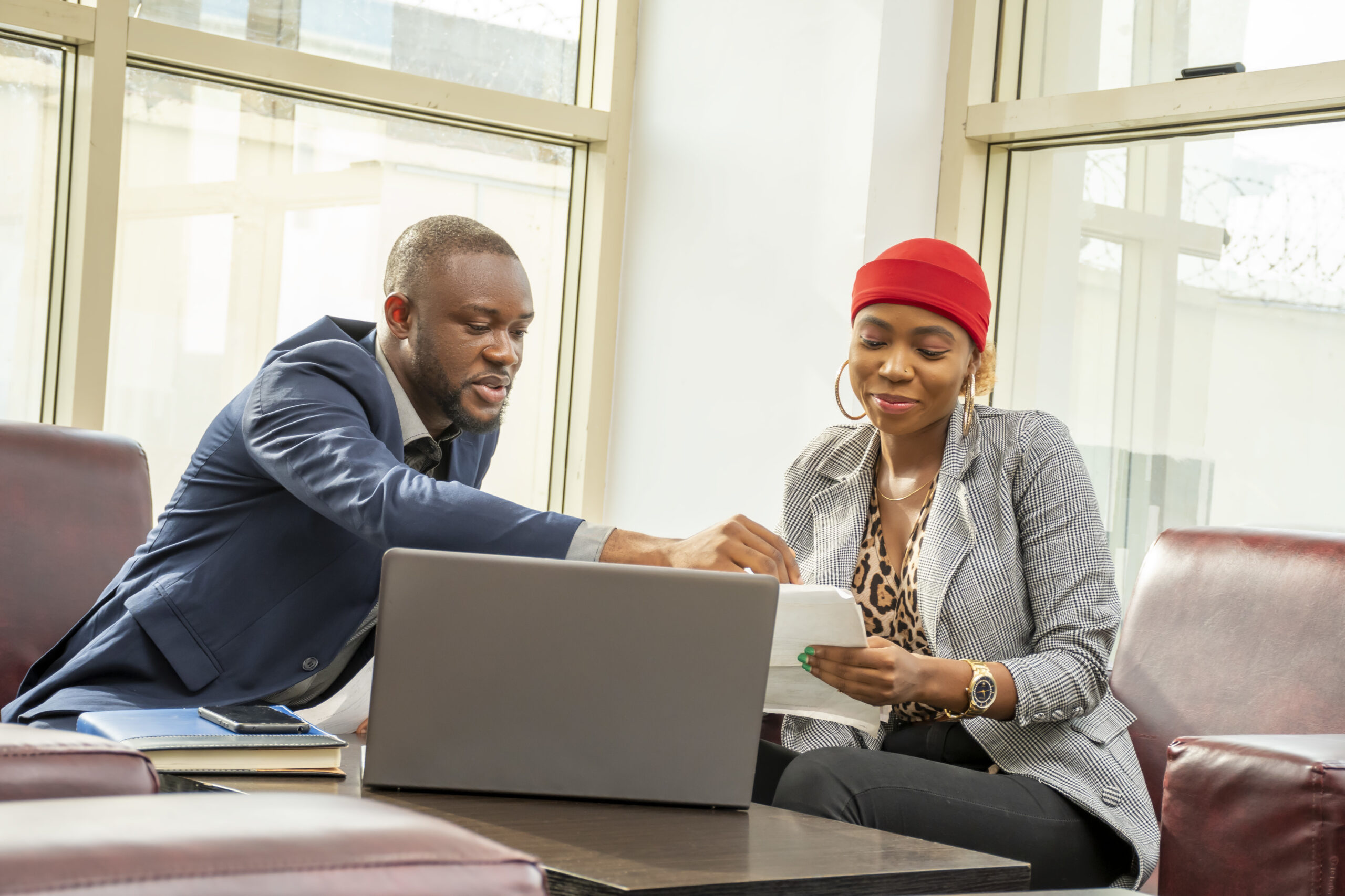 A young black businessman and woman going through some paperwork together